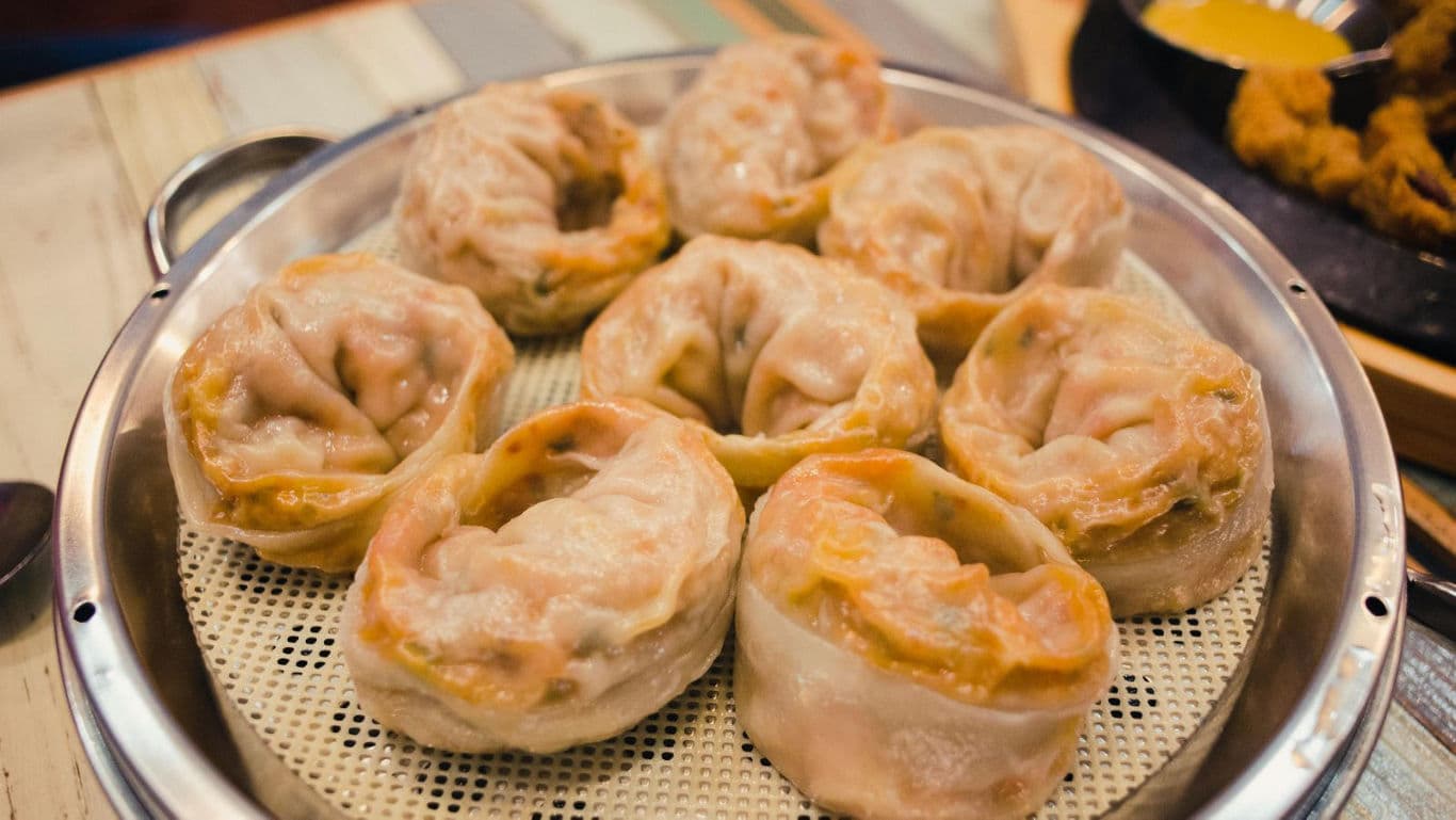 Steamed dumplings served on metal tray
