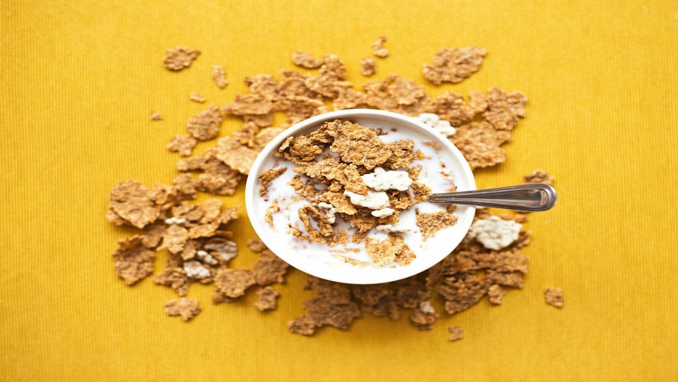 Bowl of cereal with milk on yellow