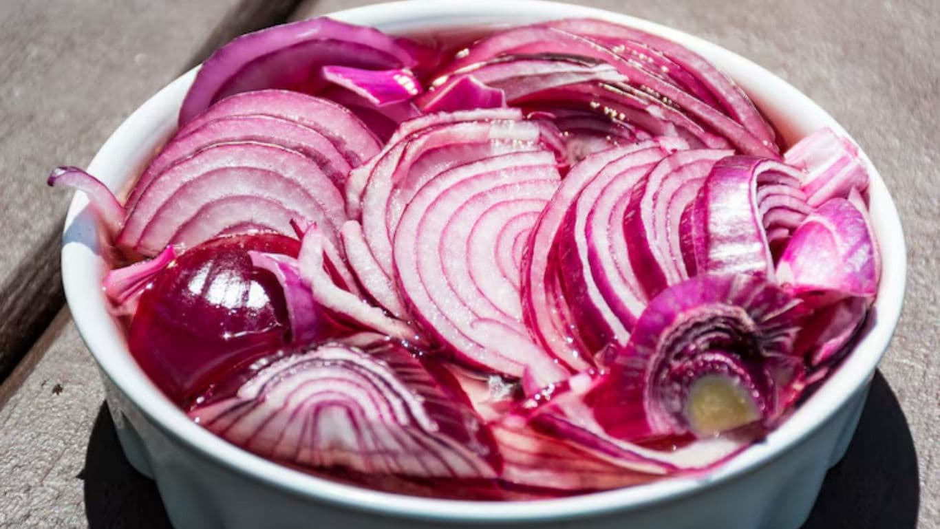 Sliced red onions in white bowl outdoors