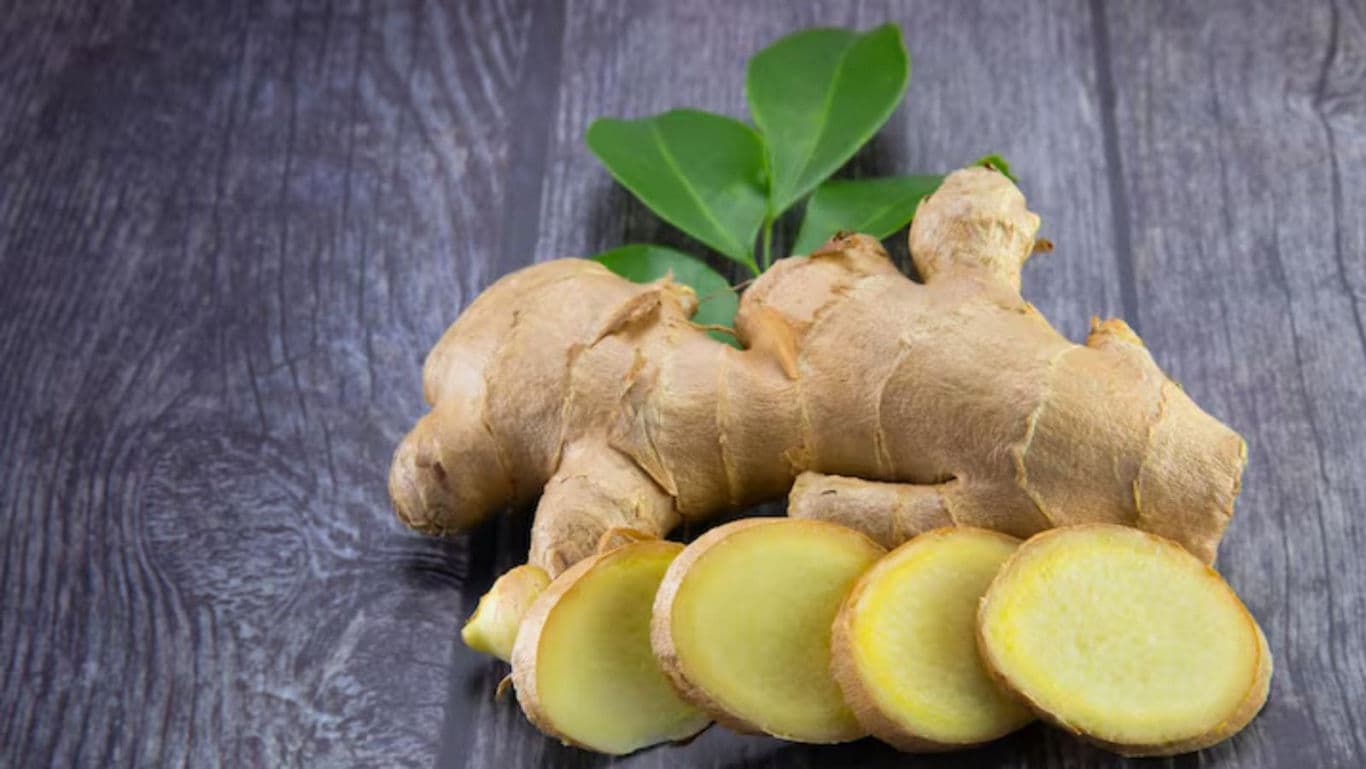 Fresh Ginger Root with Slices on Wooden Surface