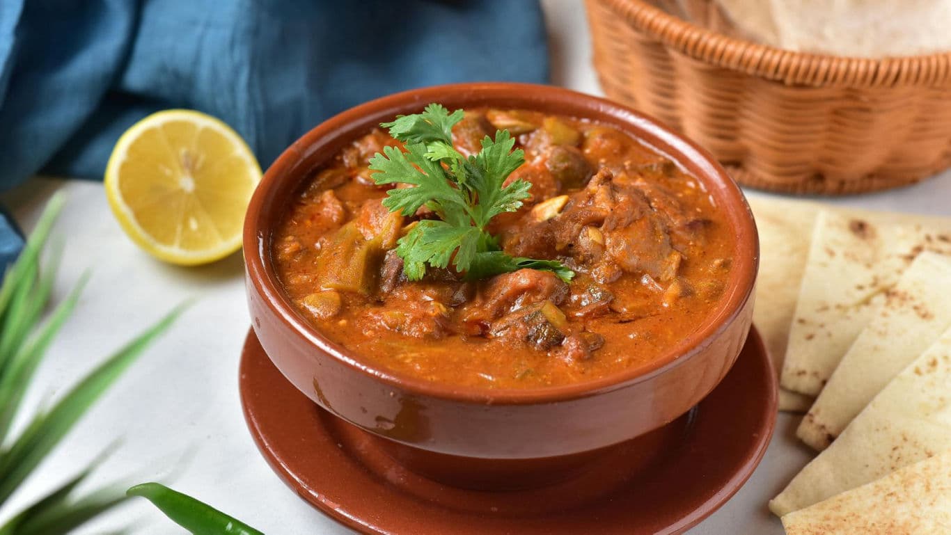 Spicy curry in ceramic bowl with bread