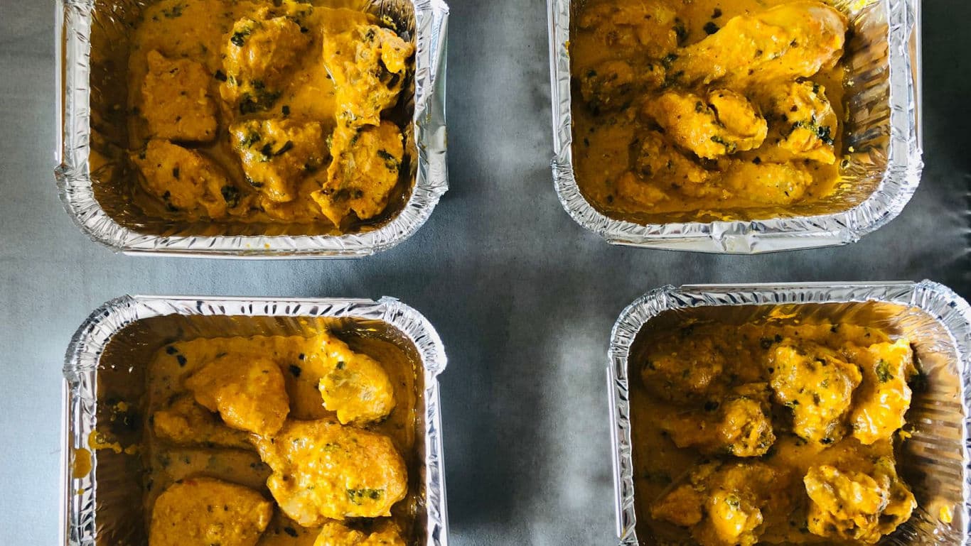 Four trays of yellow curry chicken