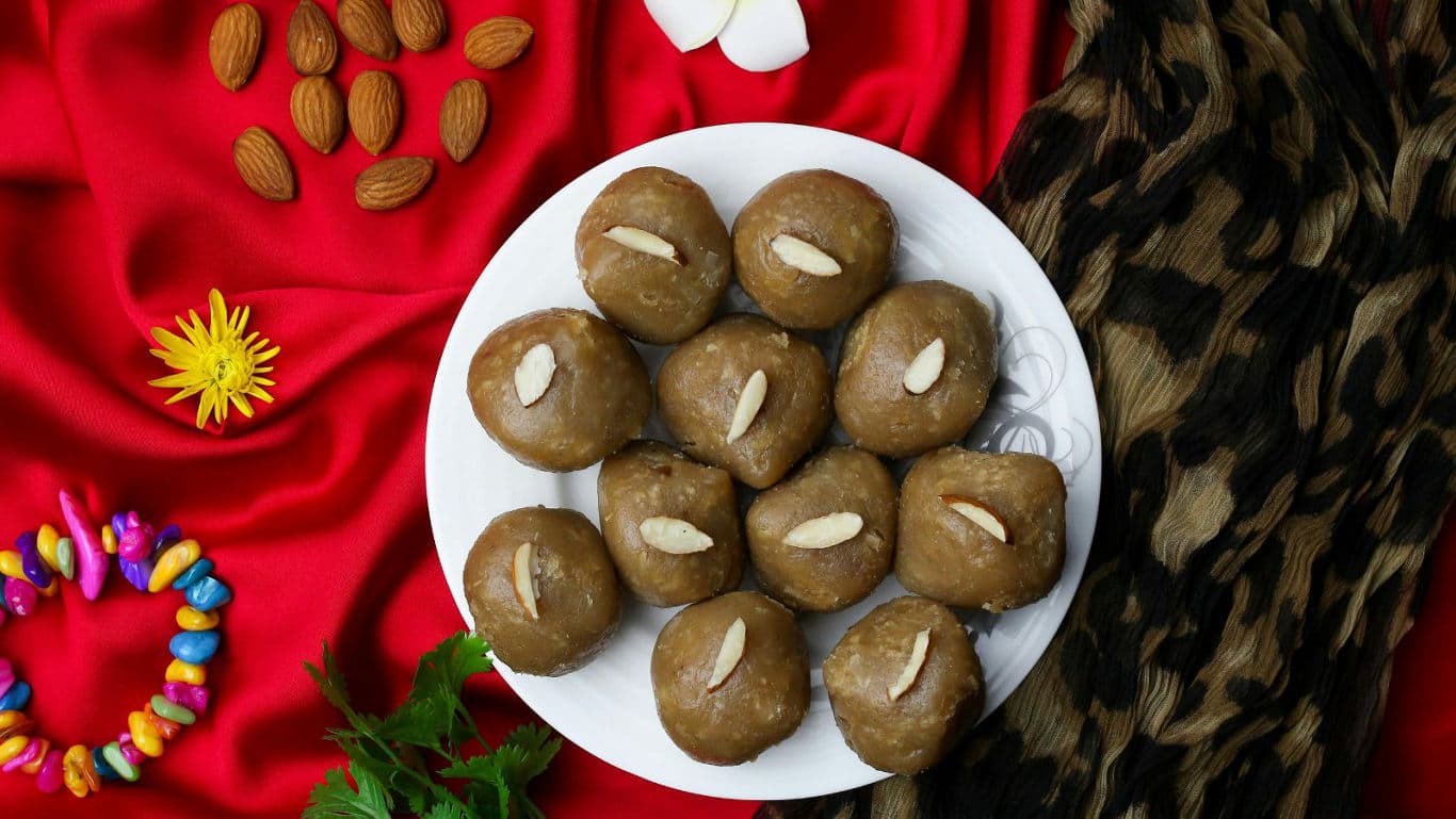 Plate of almond-topped sweets on red fabric