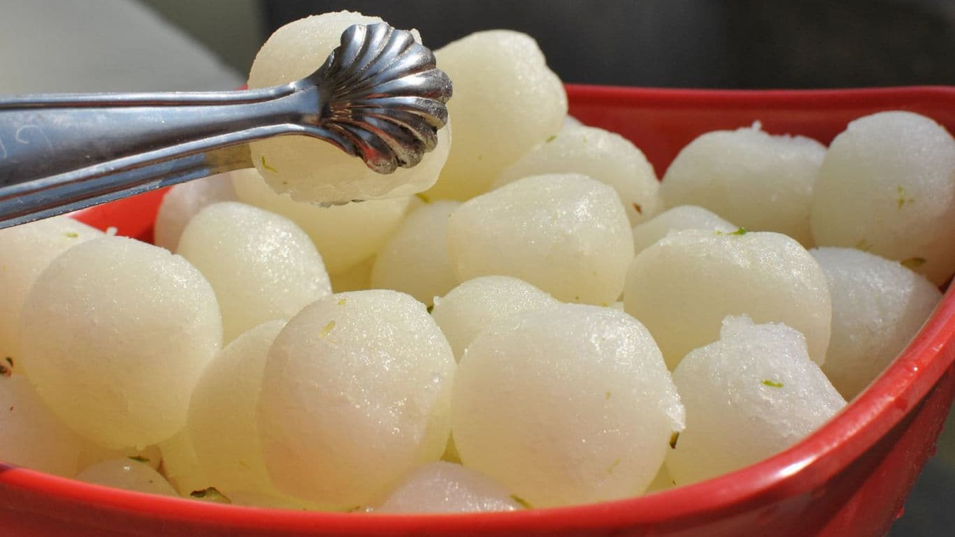 Traditional Indian rasgulla sweets in red serving bowl