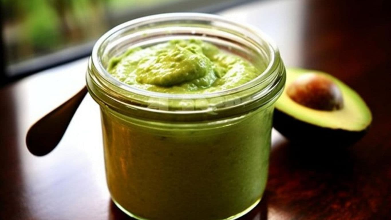 Glass jar of avocado spread on table