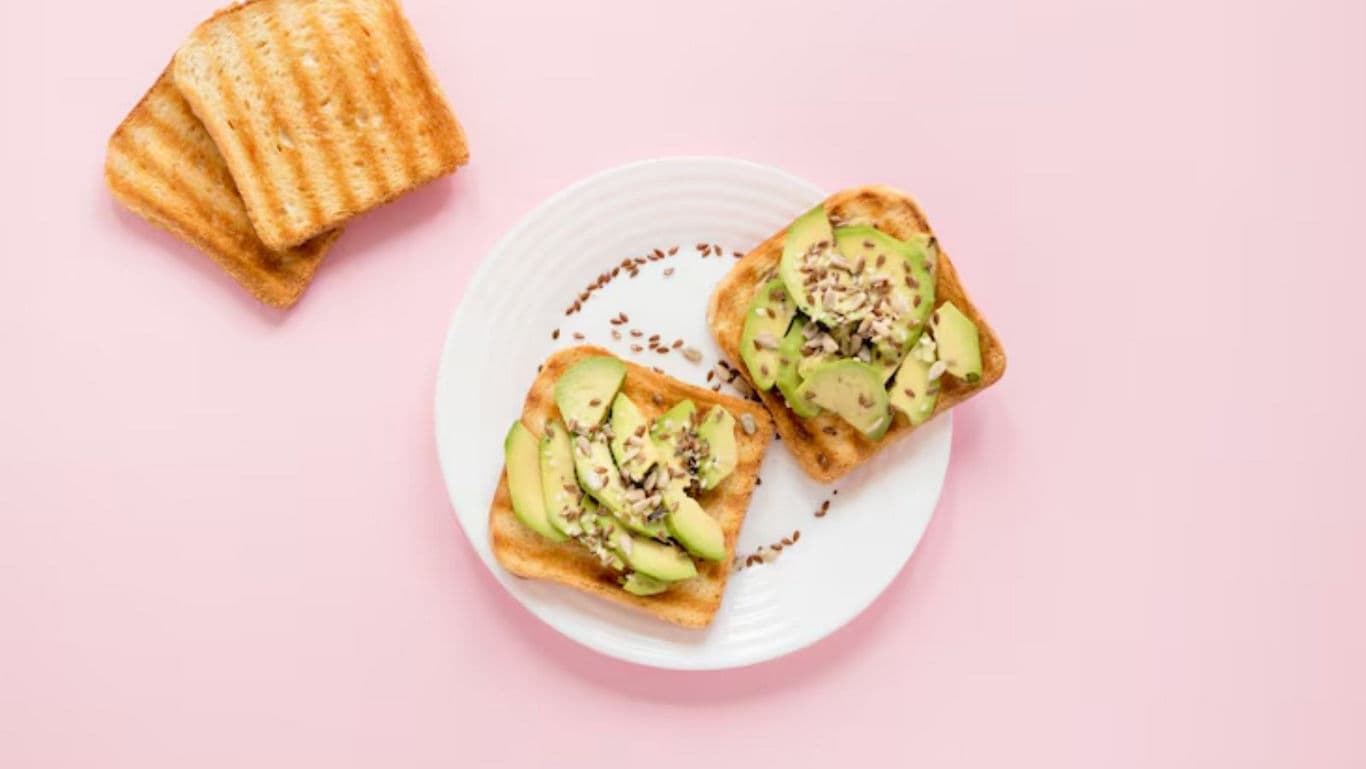 Avocado toast on white plate with seeds