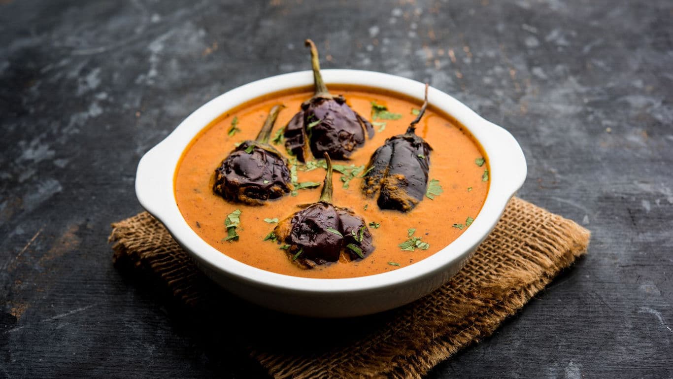 Stuffed eggplant curry in white bowl
