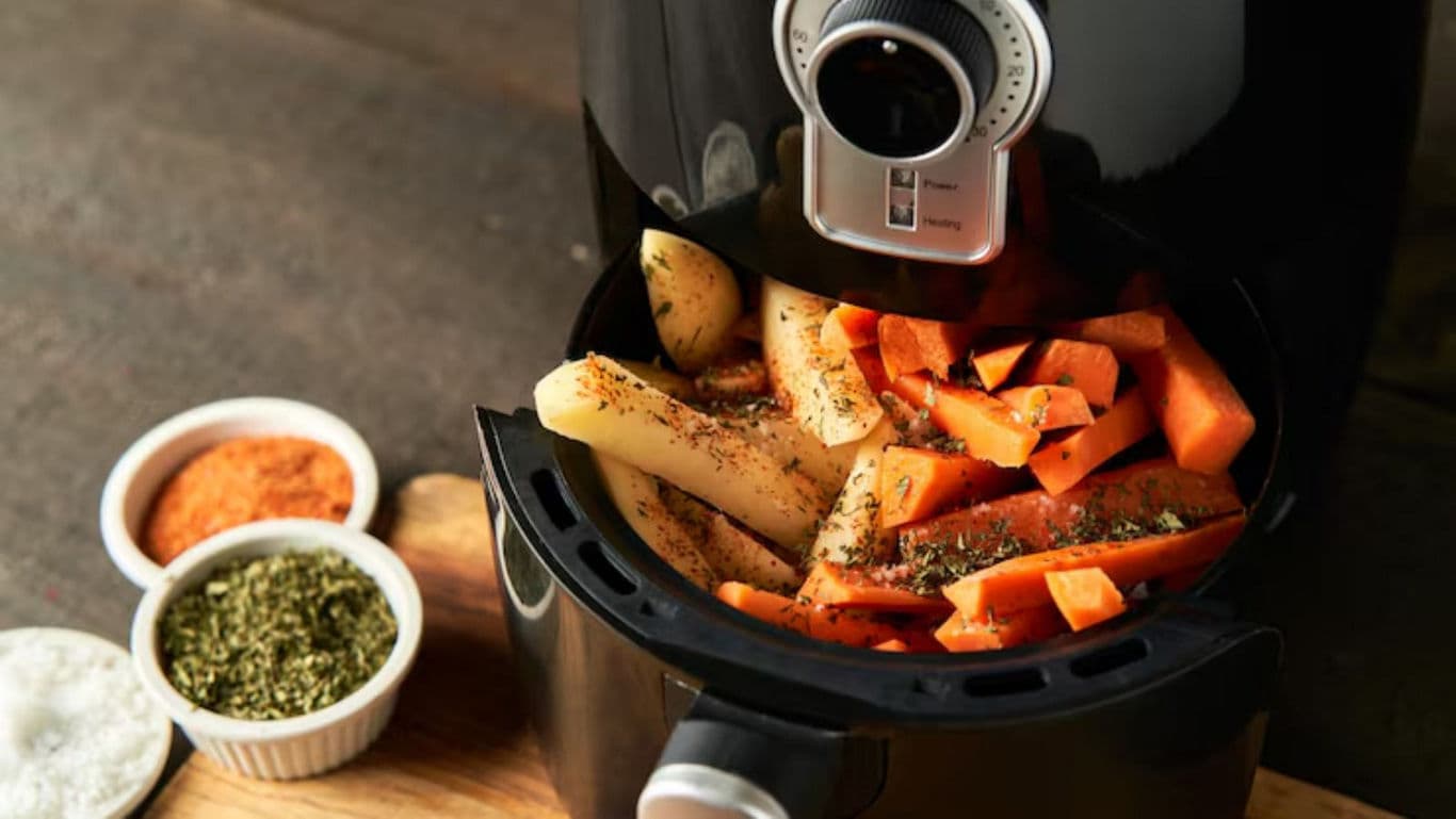 Air fryer with seasoned vegetables cooking