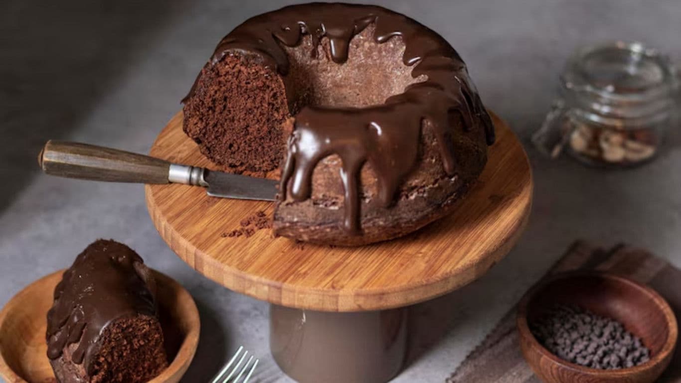 Chocolate bundt cake with ganache on wooden stand
