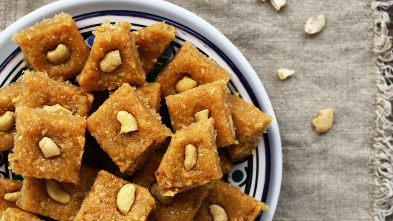 Cashew-topped sweet squares on ceramic plate