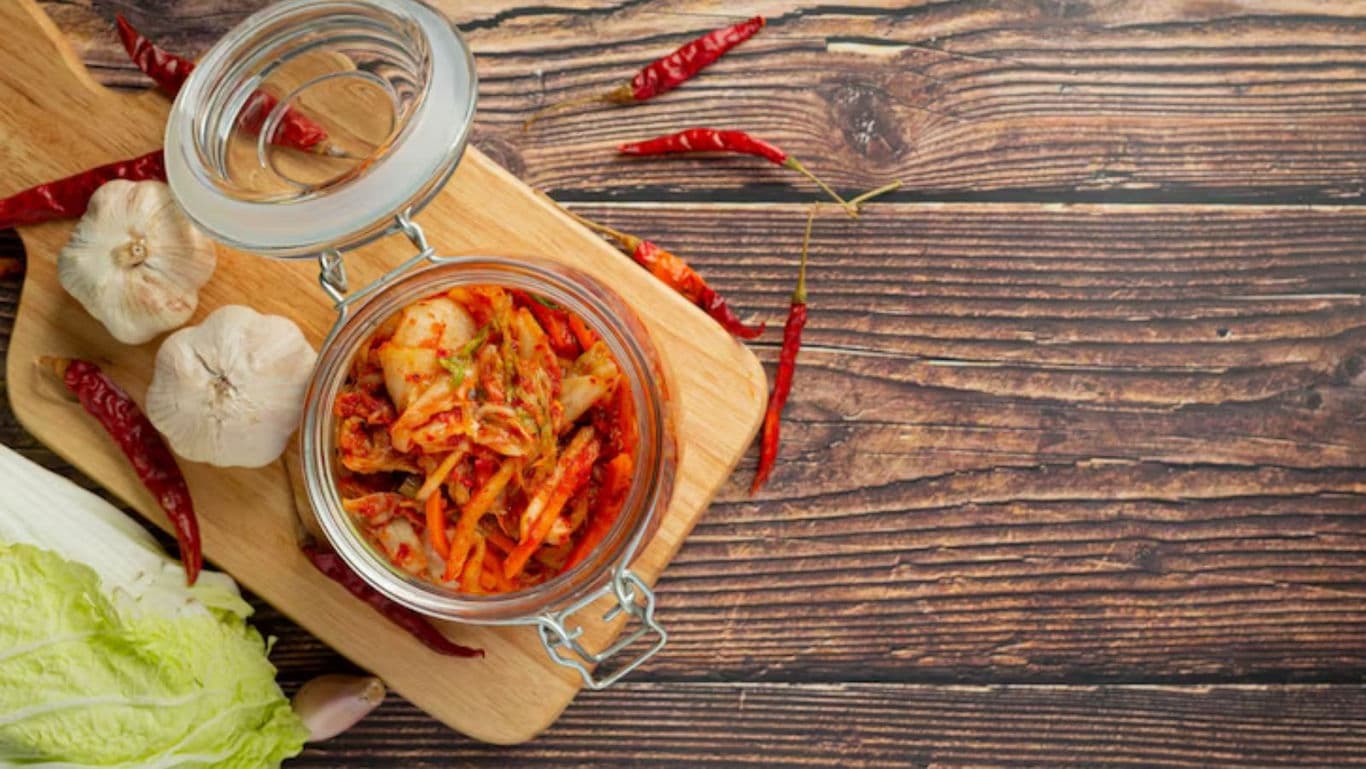 Glass jar of homemade kimchi on board
