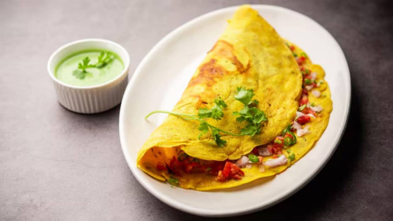 Indian chickpea omelette with chutney on white plate