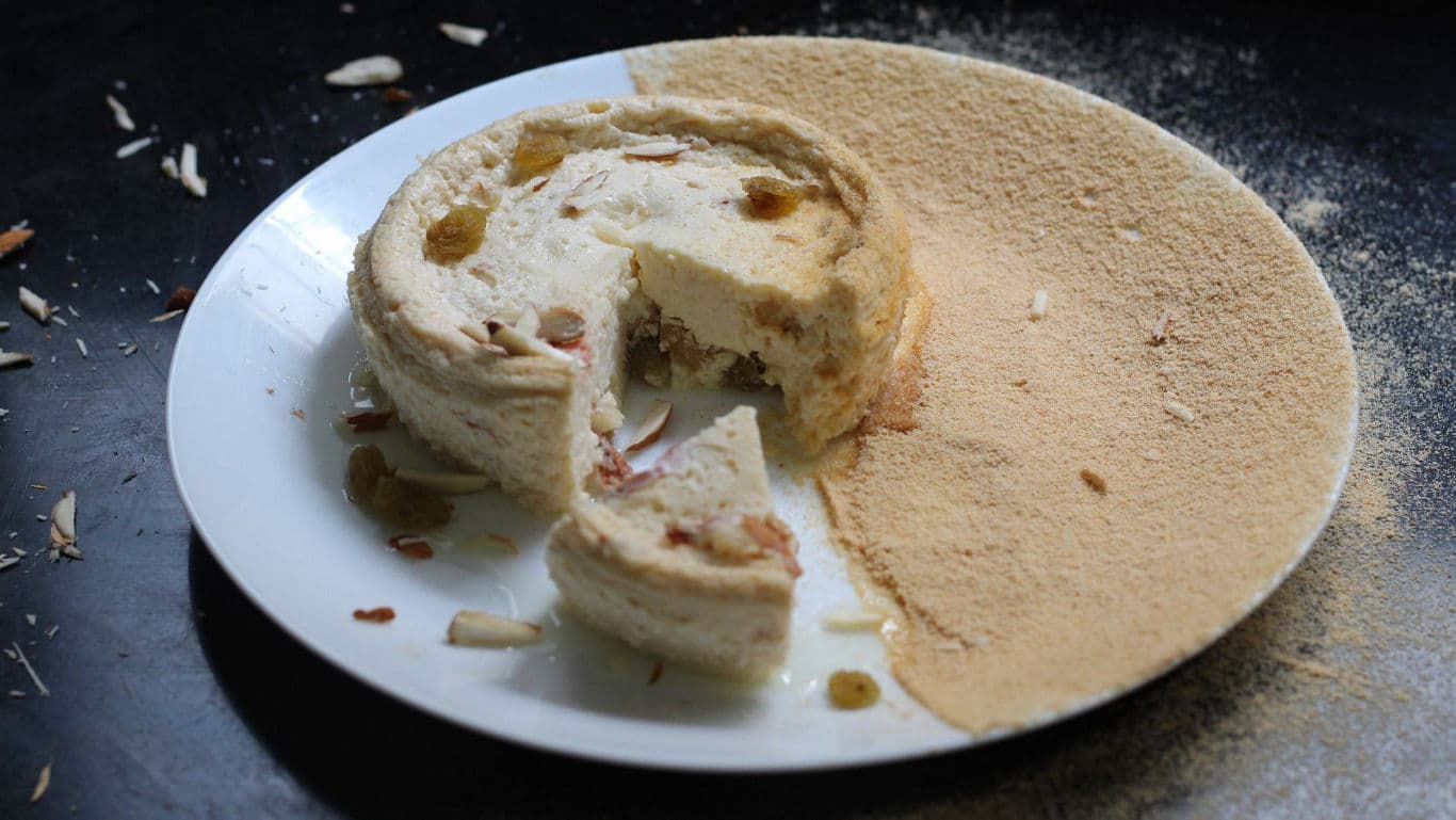 Yellow cheesecake topped with mango buttercream, a festive Bengali dessert.