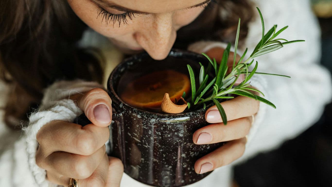 Woman enjoying herbal tea in cozy setting