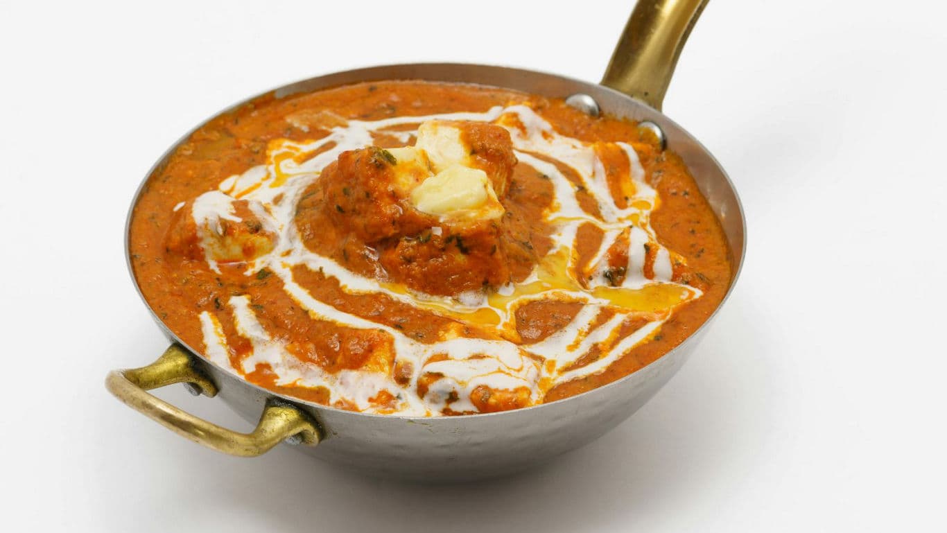 Creamy butter chicken in brass bowl