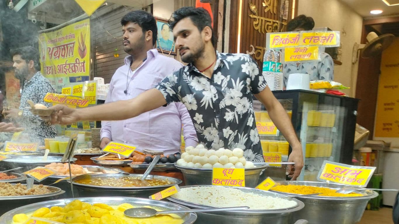 Street food vendor serving Indian snacks at stall