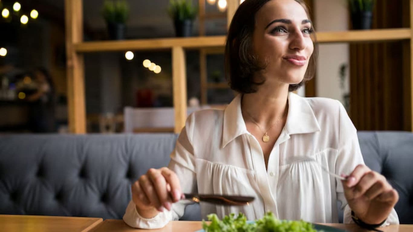 Woman dining with fresh salad indoors
