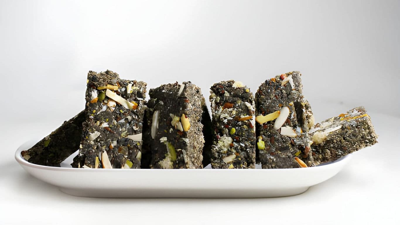 Black sesame bars with nuts on plate