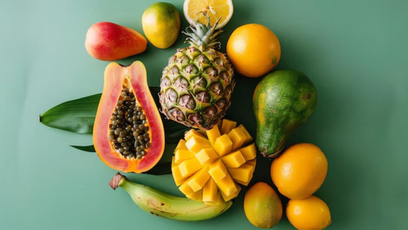 Tropical fruits assortment on green background surface