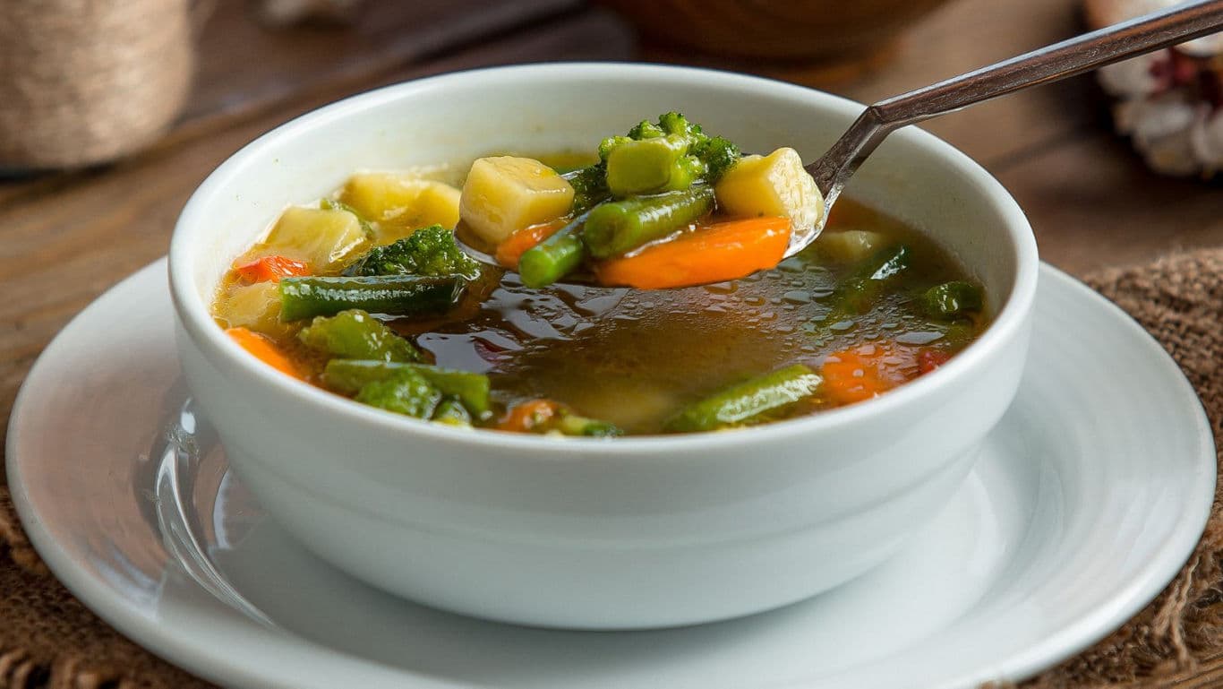 Bowl of vegetable soup with spoon