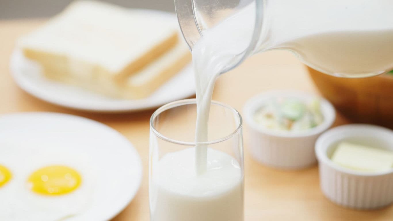 Milk Pouring into Glass with Breakfast