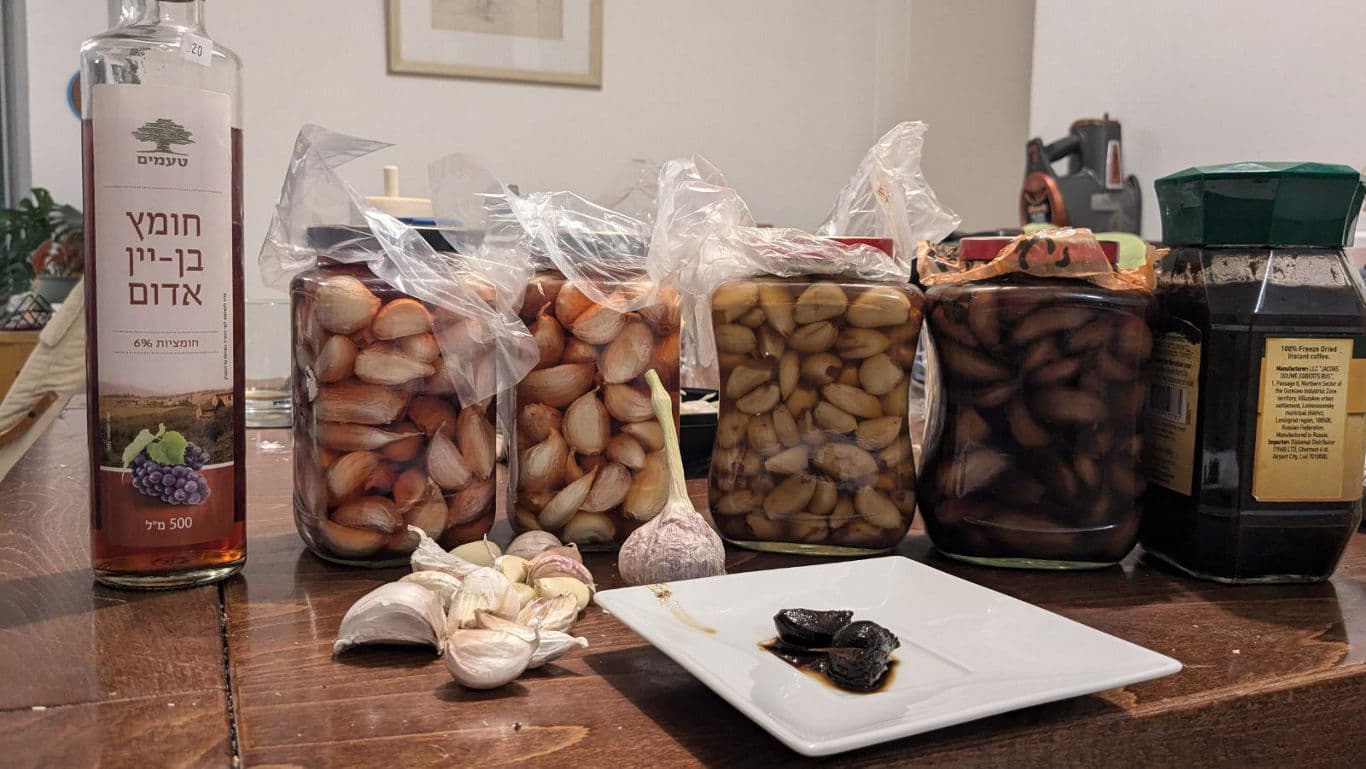 Jars of preserved garlic and red wine vinegar bottle