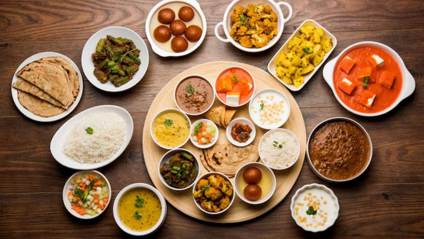 Traditional Indian Gujarati Thali with rice, rotis, vegetables, and condiments