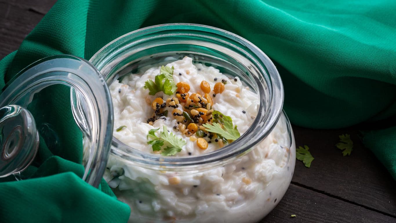 Glass jar of curd rice with garnish