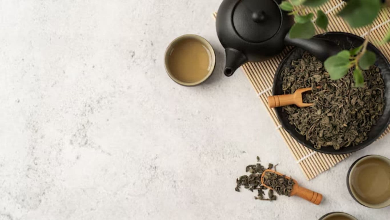 Tea leaves with teapot and cups on table