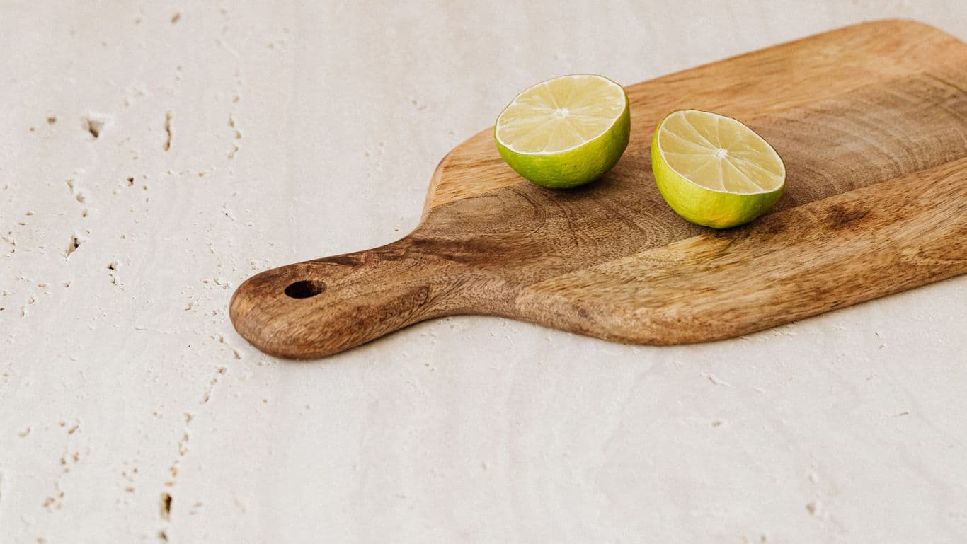 Halved lime on wooden cutting board in kitchen