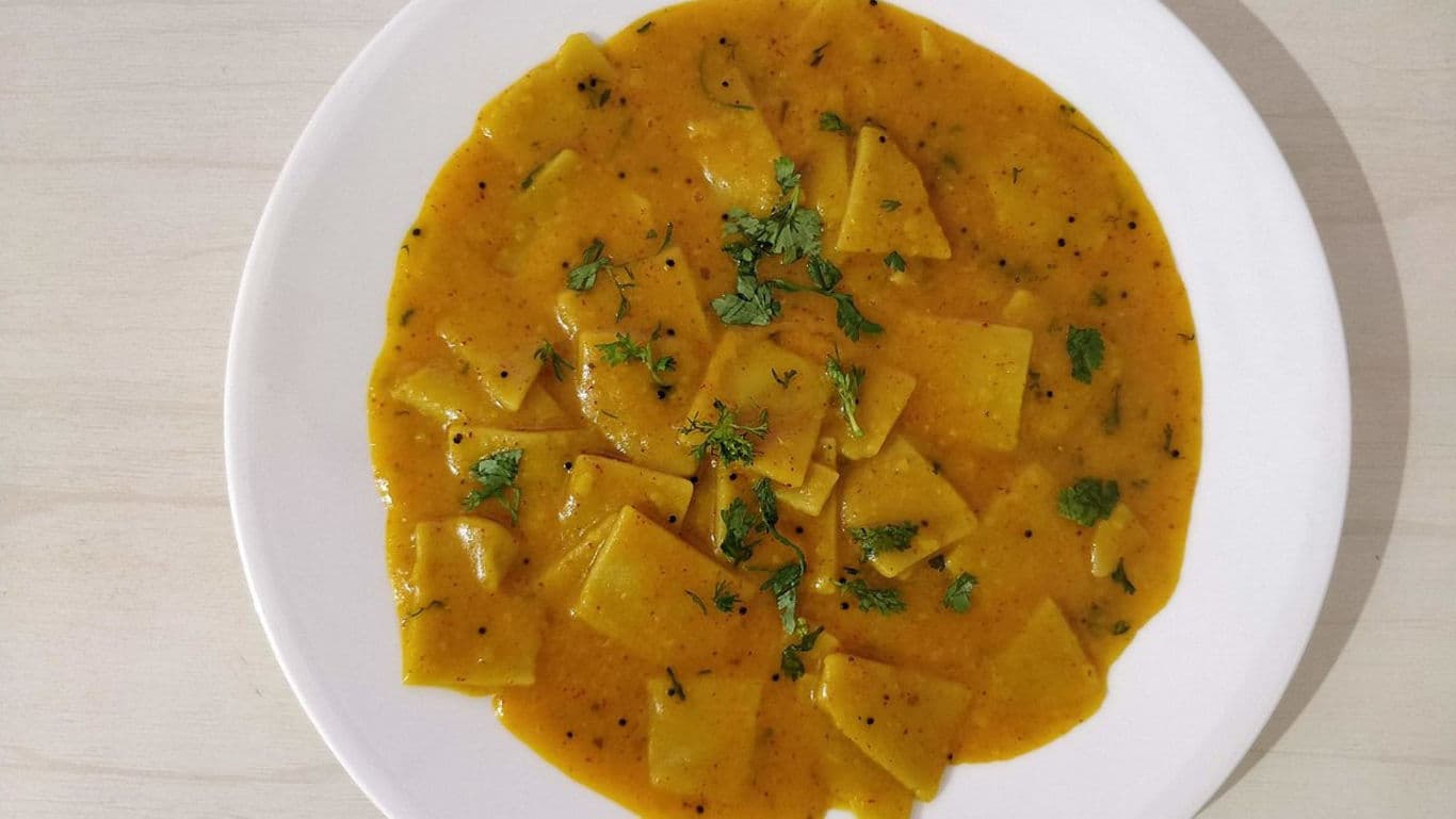 Traditional Indian curry with flat dumplings on plate