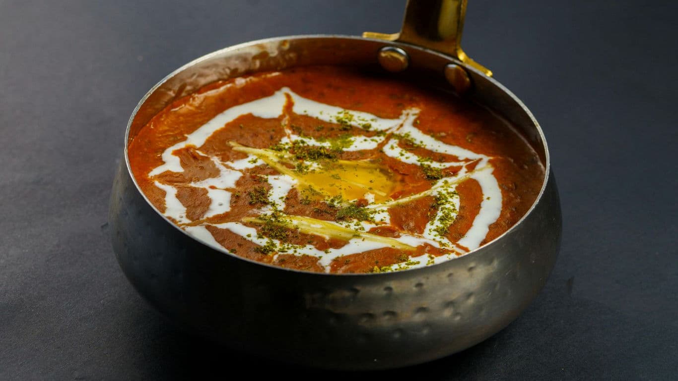 Rich Indian curry in hammered metal bowl