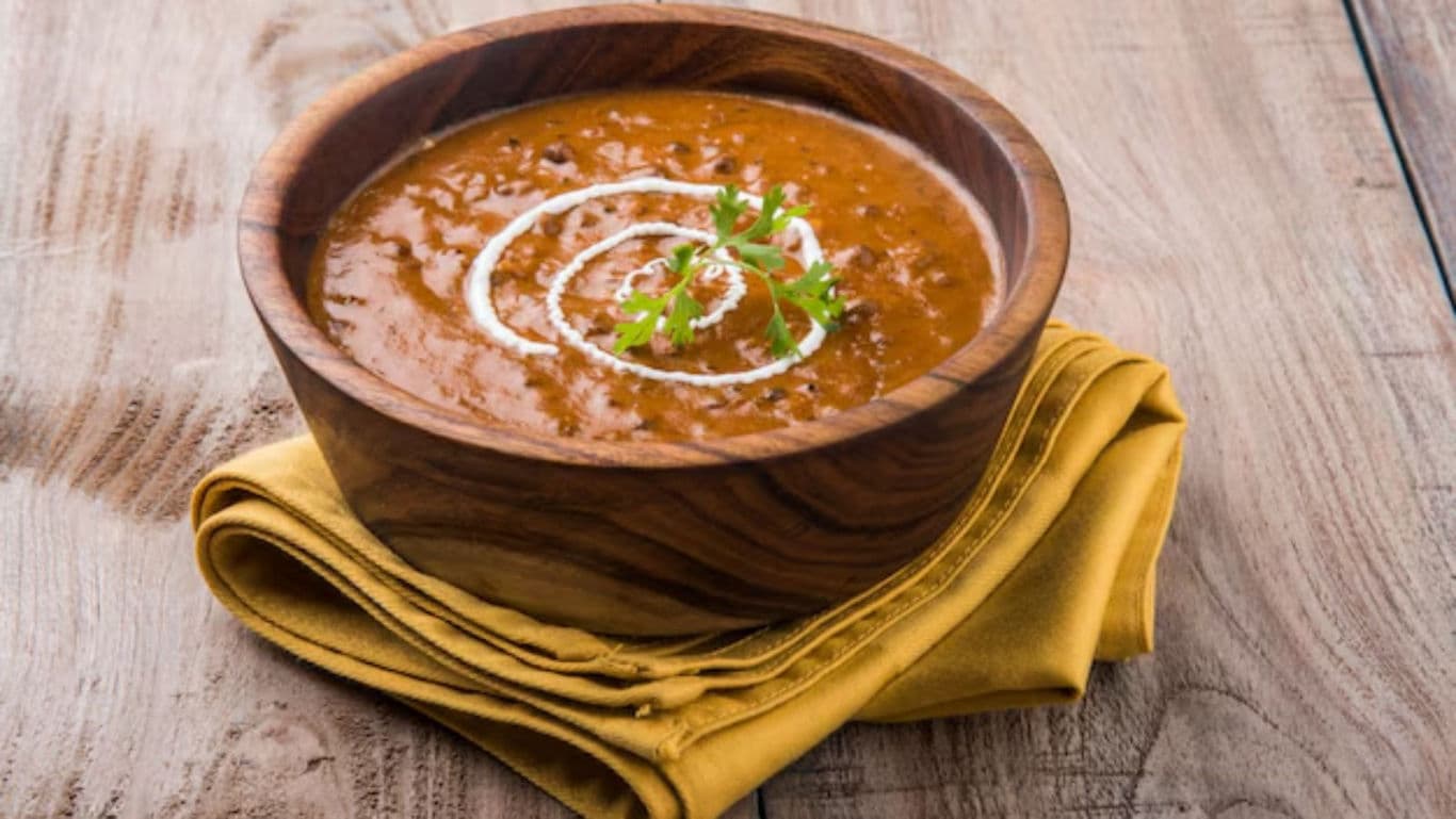 Creamy lentil curry in wooden bowl on napkin