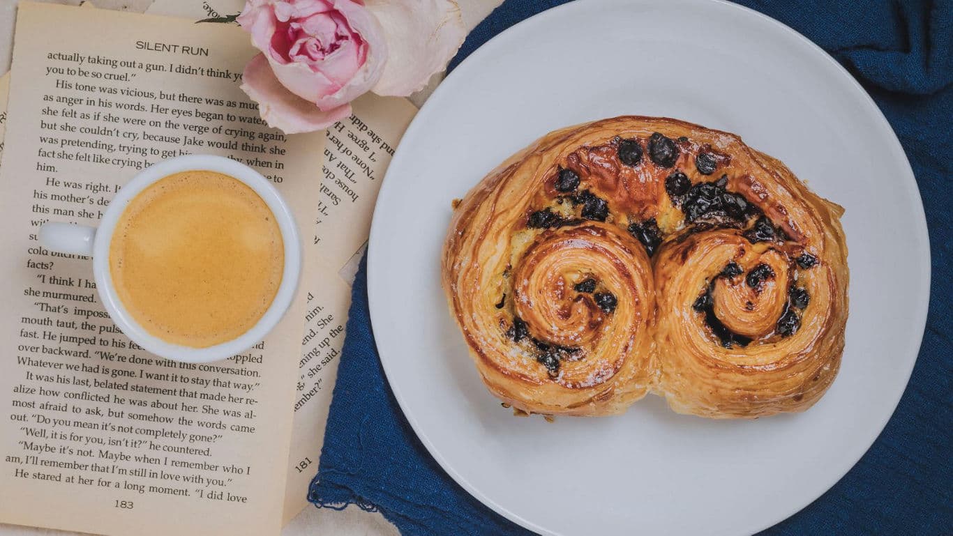 Pastry with coffee and open book
