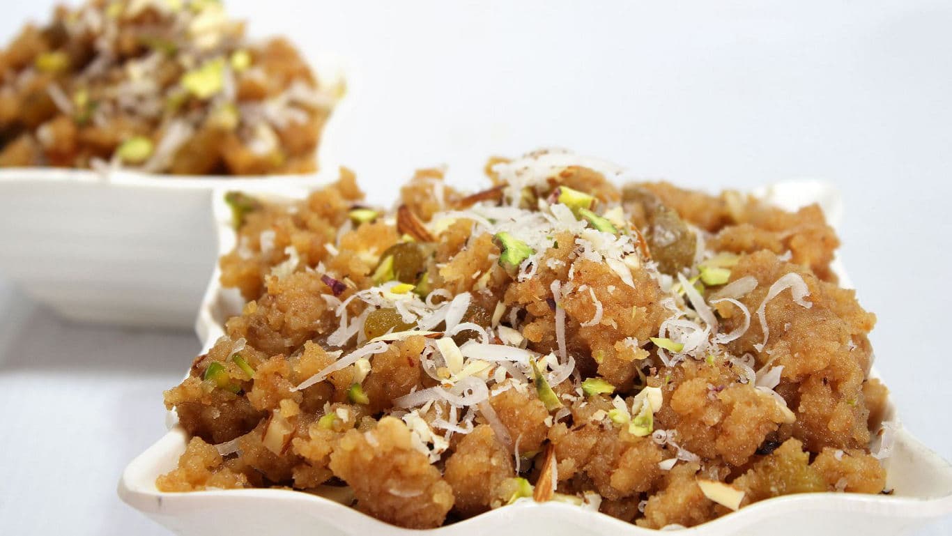 Freshly made coconut laddoos coated with desiccated coconut.
