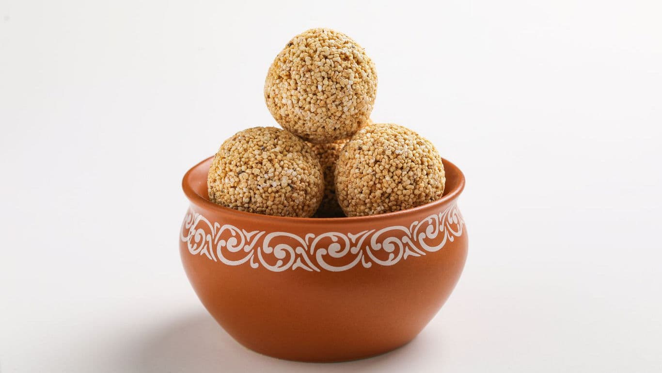 Freshly made coconut laddoos coated with desiccated coconut.