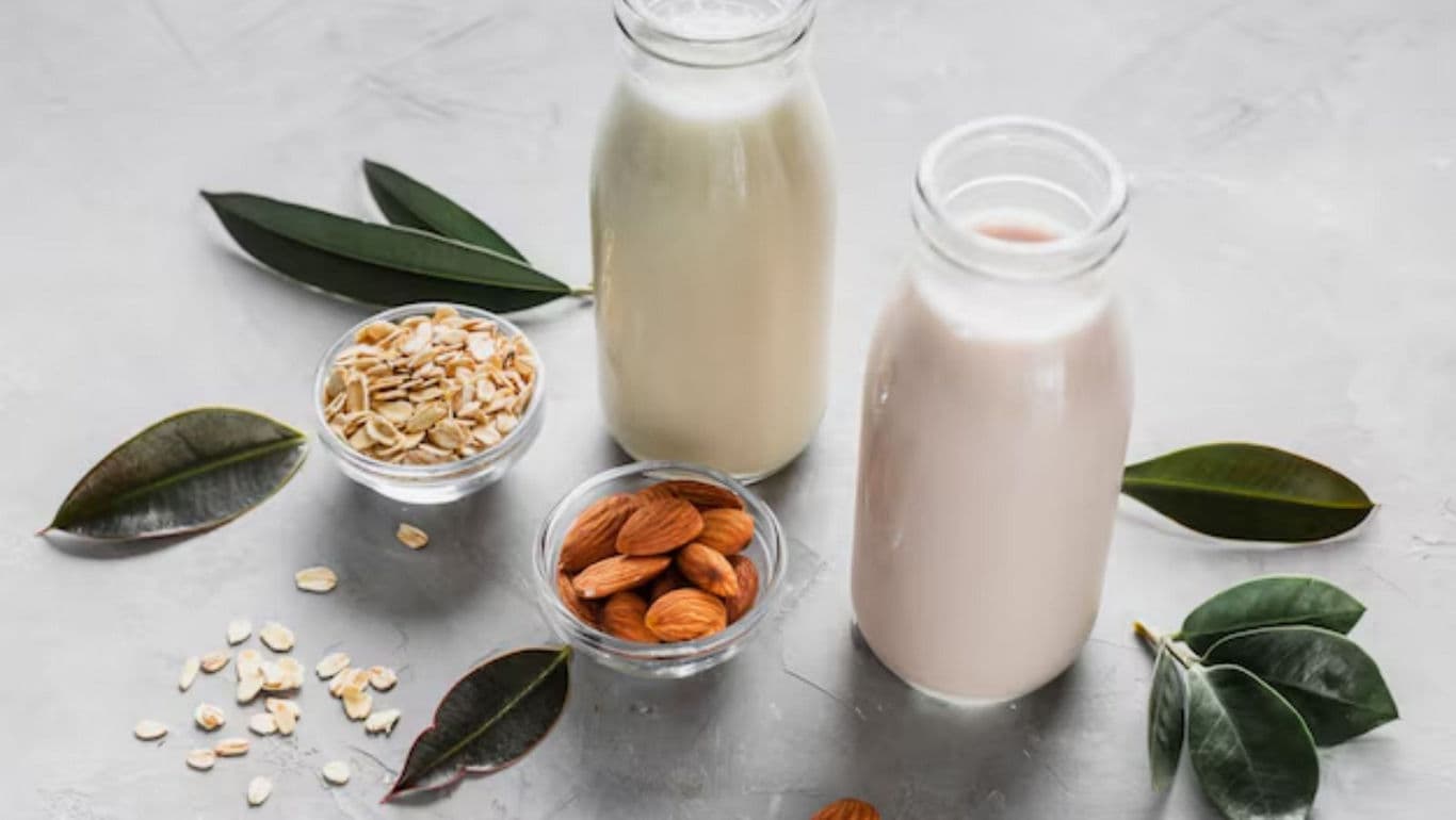 Bottles of Almond and Oat Milk with Ingredients