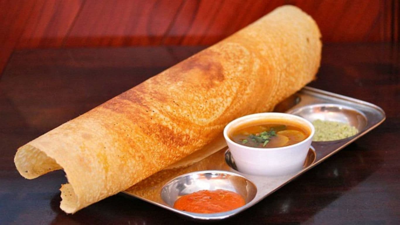 Crispy dosa served with sambar and chutneys