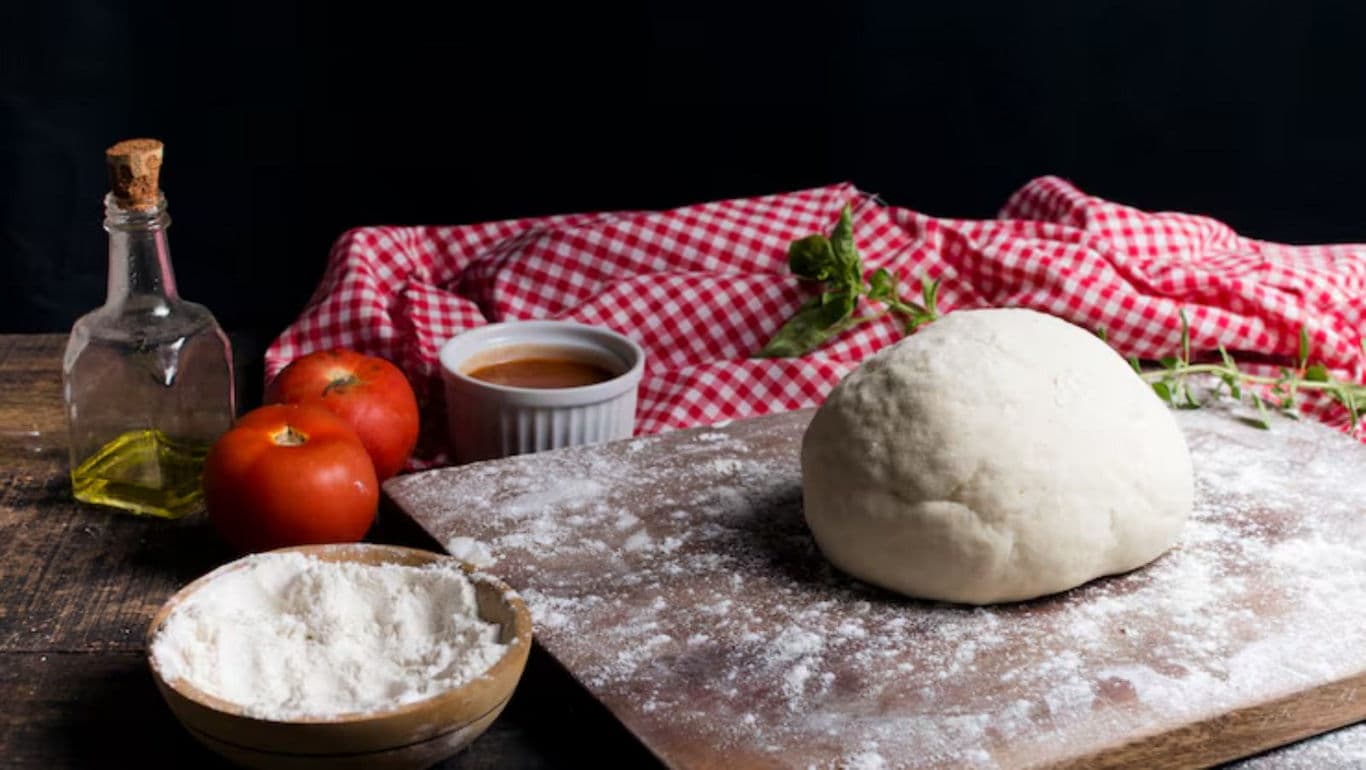 Fresh Pizza Dough with Ingredients on Table