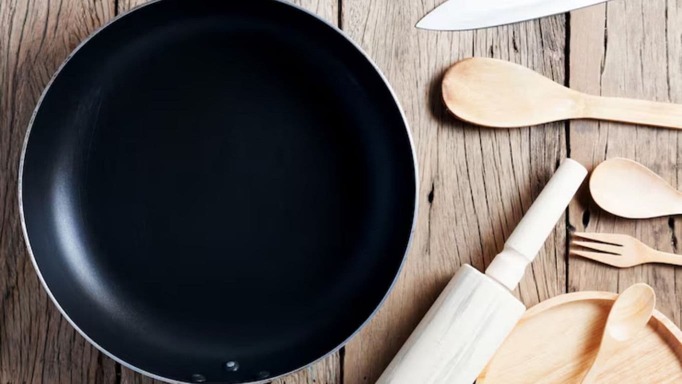 Nonstick frying pan with wooden kitchen utensils