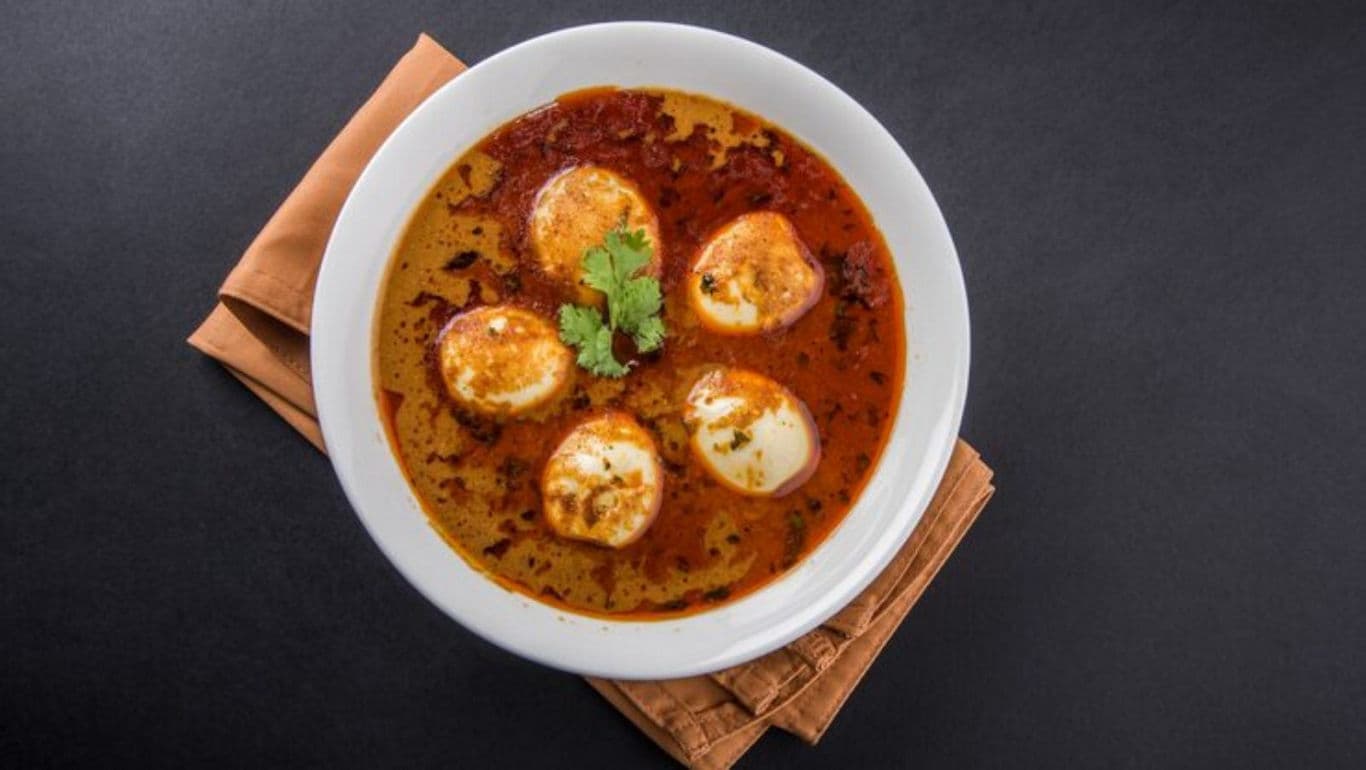 Spicy egg curry in white bowl