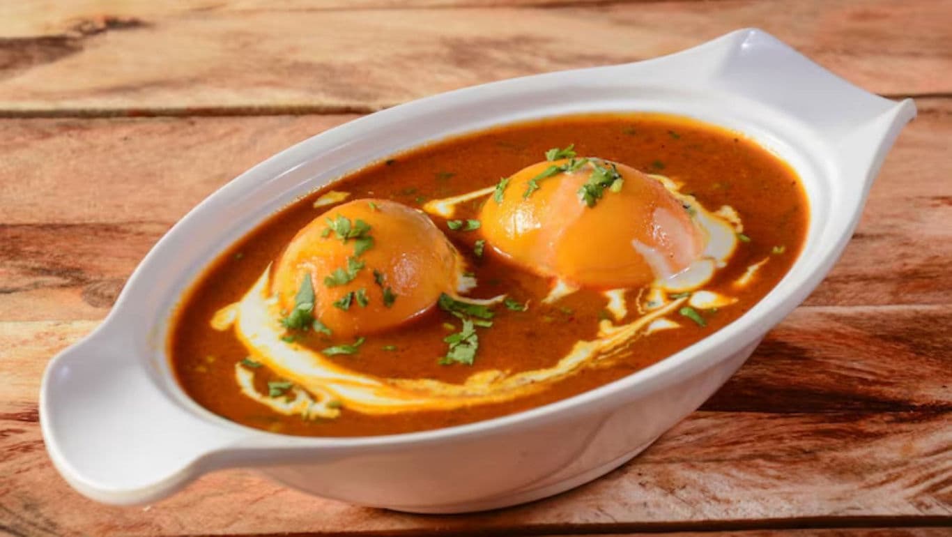 Egg curry in white oval dish