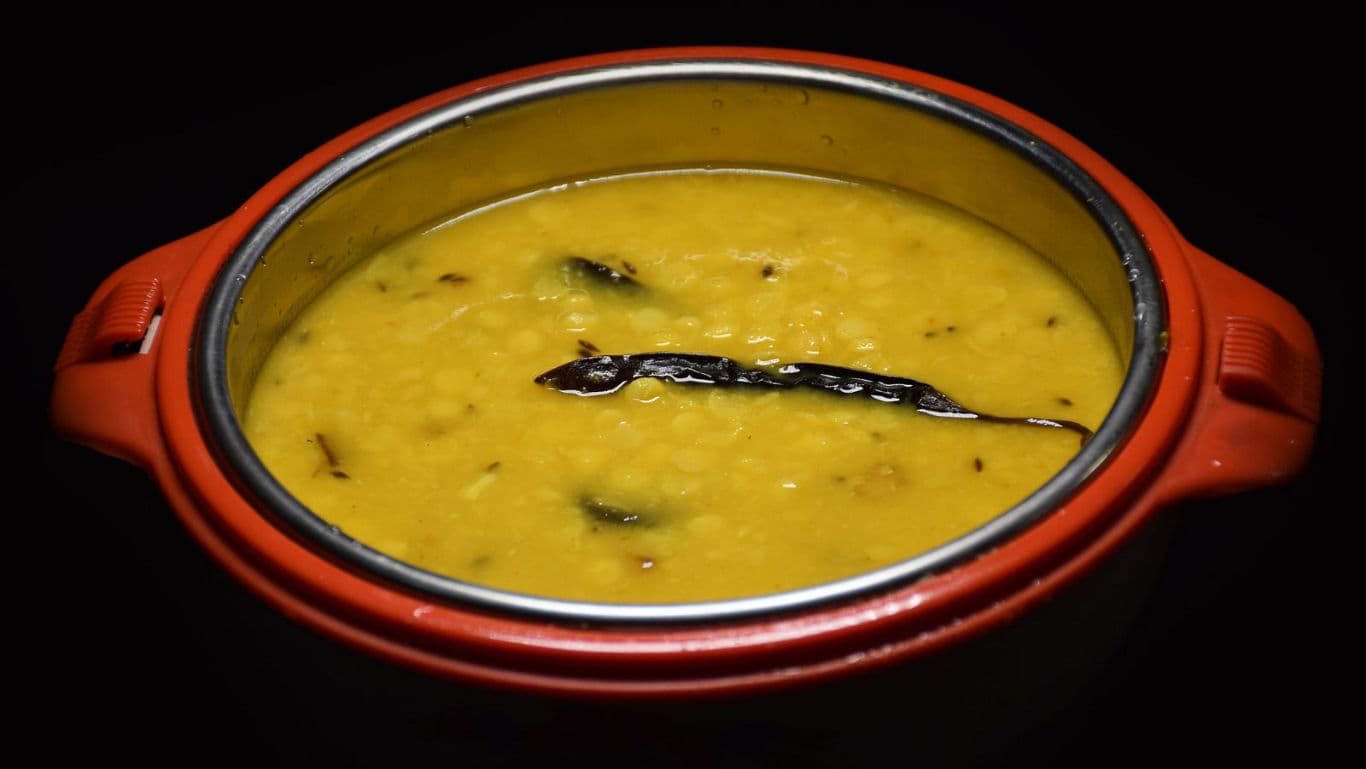 Traditional lentil curry in red pot