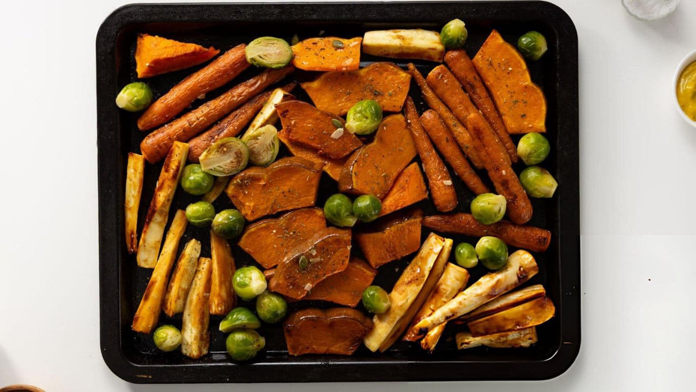 Roasted vegetables on black baking tray