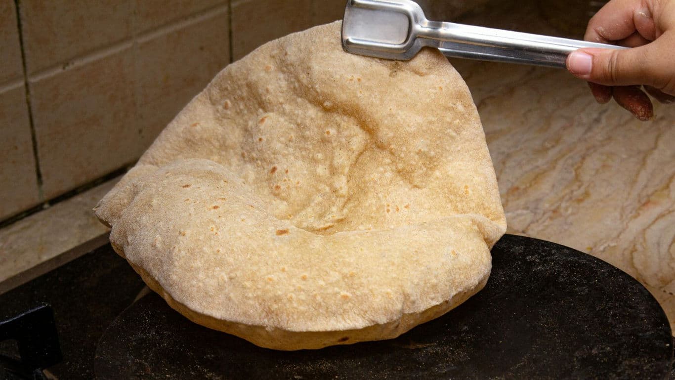 Cooking puffed roti on stovetop
