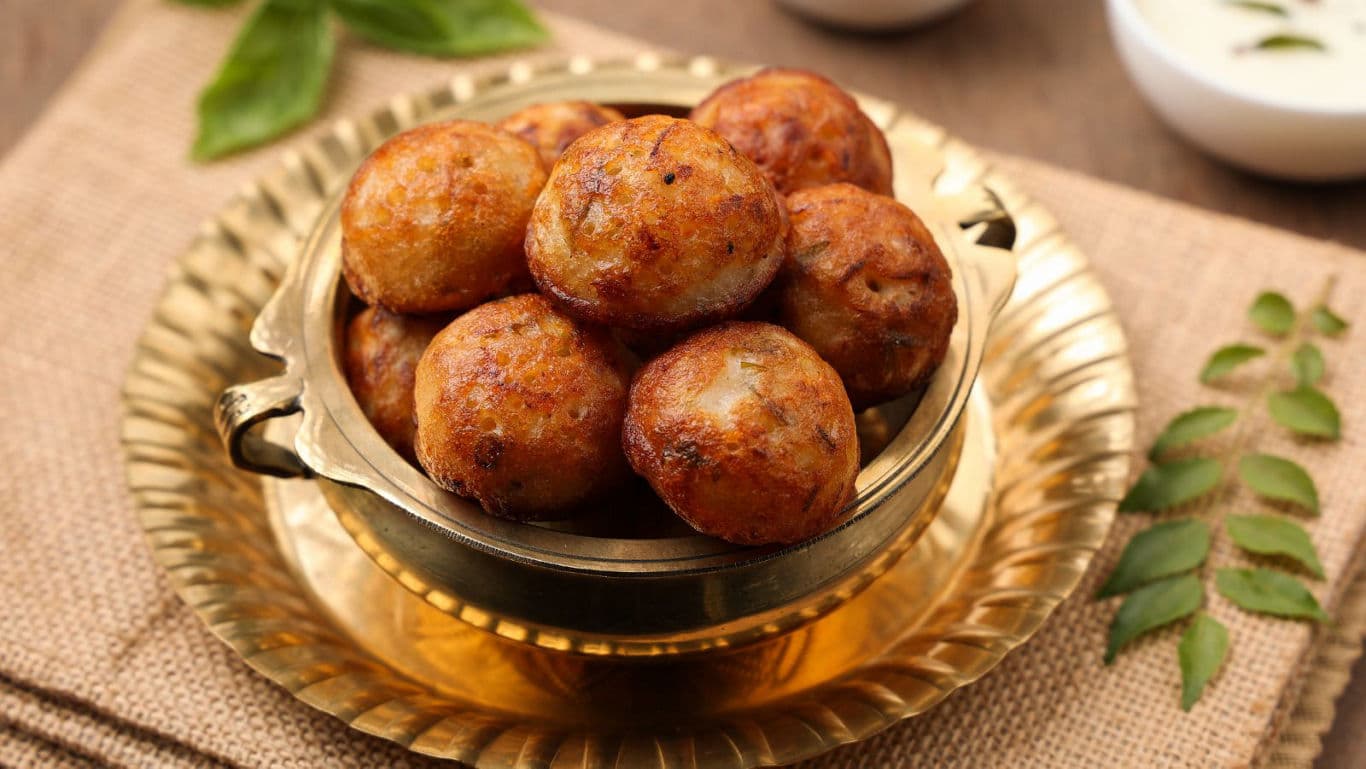 Golden fried savory balls in brass bowl