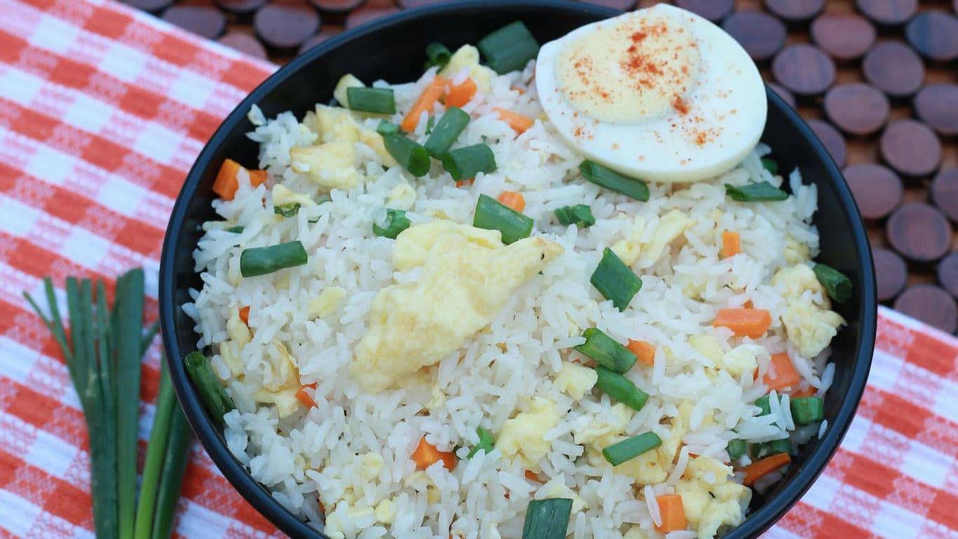 Egg fried rice with vegetables in black bowl