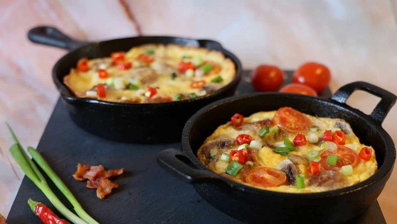 Vegetable frittatas in cast iron skillets with garnish