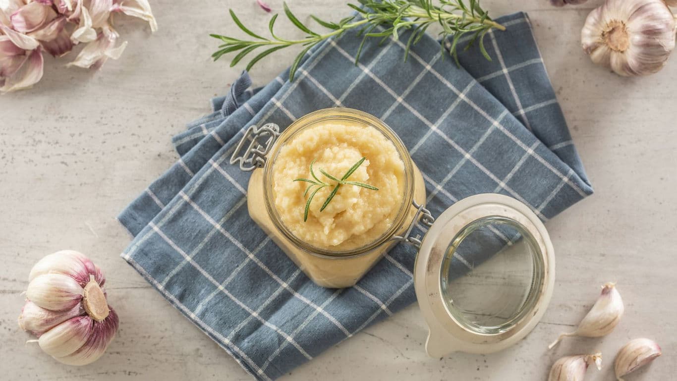 Jar of homemade garlic paste on blue cloth