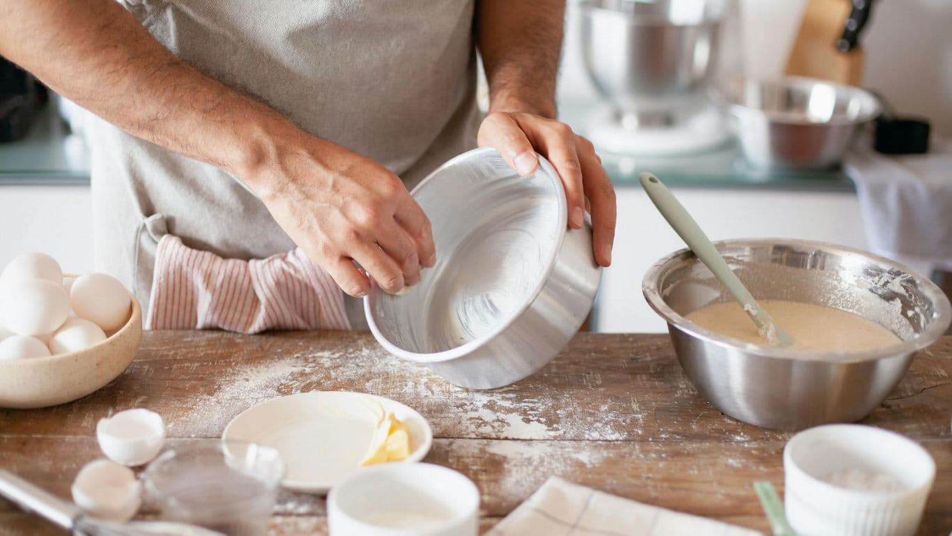 Person preparing cake batter in home kitchen